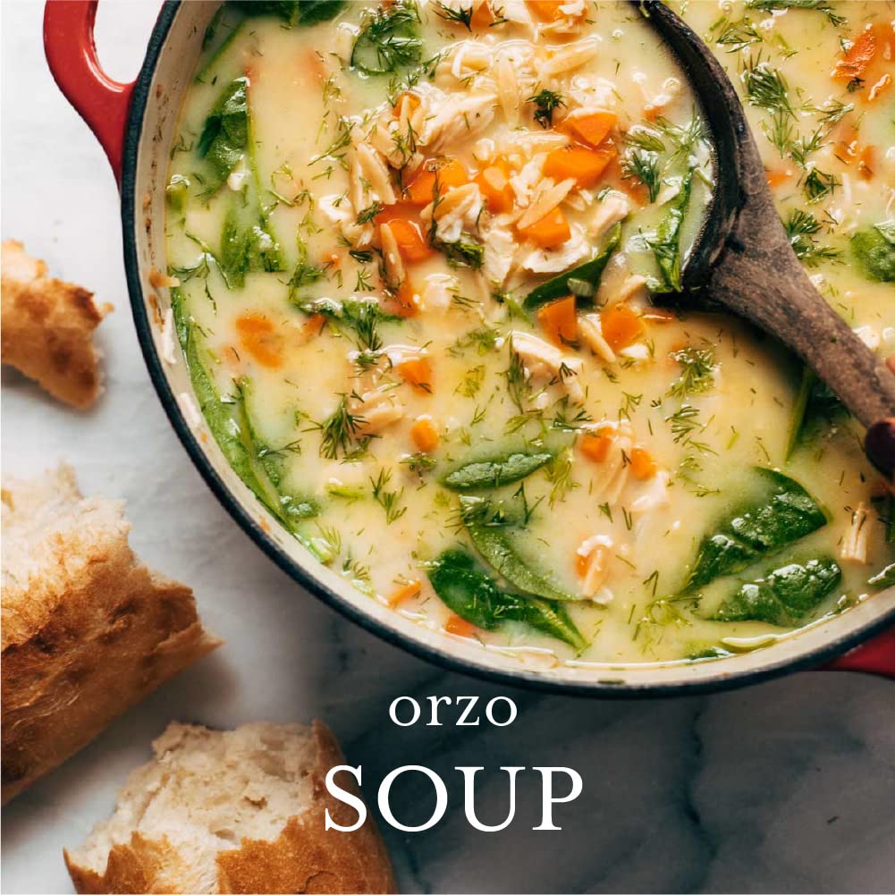 Orzo soup in a pot with bread on the side