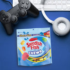 Swedish Fish Chews package with gaming controller, keyboard, and headphones on a blue background