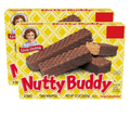 Two boxes of Little Debbie Nutty Buddy chocolate wafer bars stacked on a white background. The front box shows three chocolate wafer bars, one broken to reveal the peanut butter filling, with the brand name 'Nutty Buddy' in large red letters on a yellow patterned background.